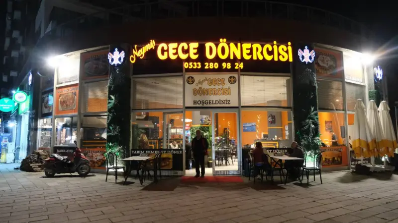 Neymiş Gece Dönercisi'nin gece ışıklı dükkan önü ve açık hava masaları